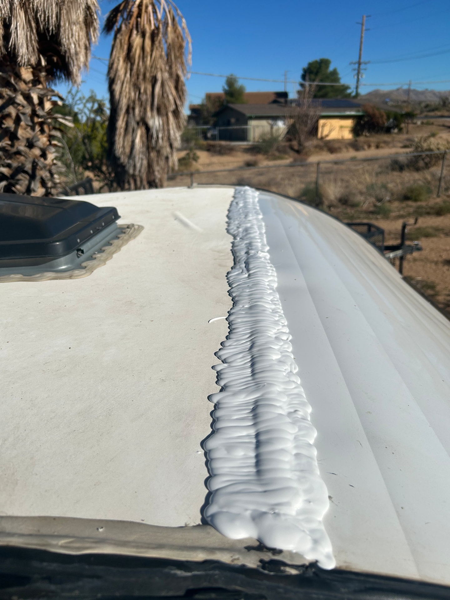 Fresh sealant applied along an RV roof seam